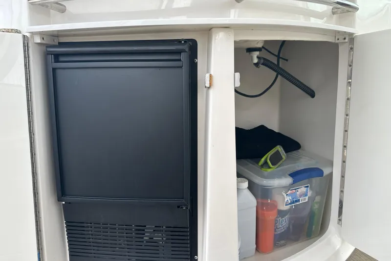 Slide: The Image of Storage compartment on a 2005 Chaparral Signature 350 boat with refrigerator and supplies. - 28