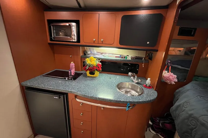 Slide: The Image of 2005 Chaparral Signature 350 yacht interior kitchen with sink, microwave, and floral decor. - 34