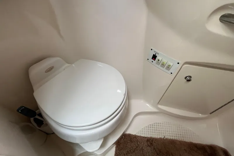 Slide: The Image of 2005 Chaparral Signature 350 boat bathroom with toilet and control panel. - 48