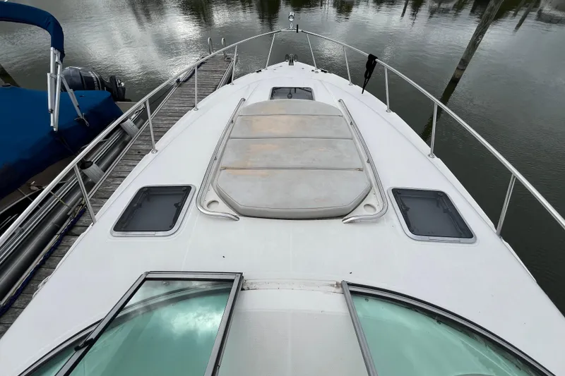 Slide: The Image of 2005 Chaparral Signature 350 boat deck with hatches, docked by calm water. - 7