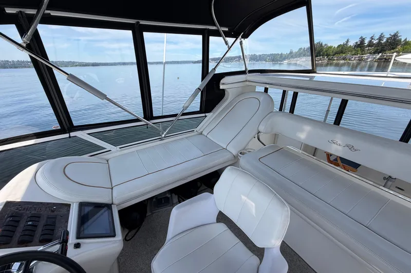 Slide: The Image of 1997 Sea Ray 370 Aft Cabin interior with white seating, overlooking serene water. - 10
