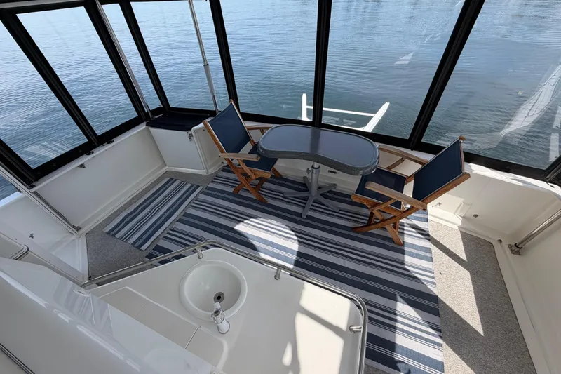 Slide: The Image of 1997 Sea Ray 370 Aft Cabin interior with table, chairs, and striped rug. - 11