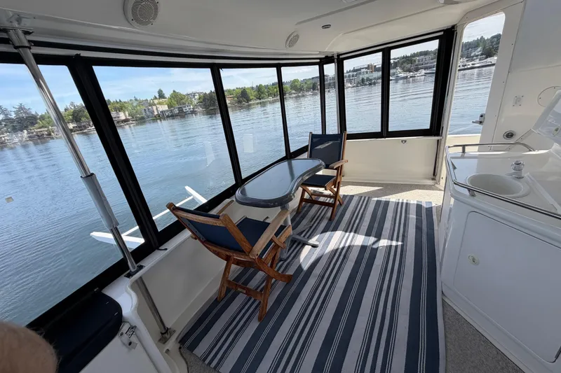 Slide: The Image of Interior of 1997 Sea Ray 370 Aft Cabin with lake view, table, and chairs. - 13