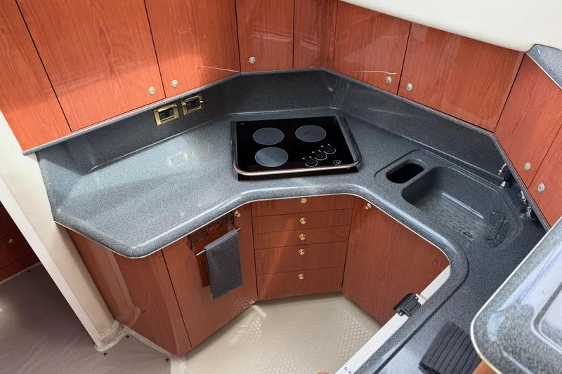 Slide: The Image of Luxurious 1997 Sea Ray 370 Aft Cabin kitchen with sleek countertops and modern appliances. - 21