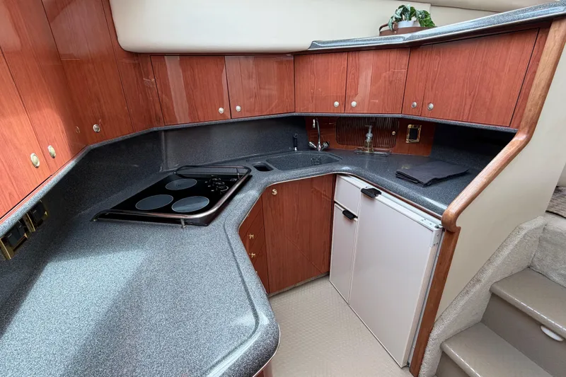Slide: The Image of Luxurious 1997 Sea Ray 370 Aft Cabin yacht kitchen with wood cabinetry and modern appliances. - 22