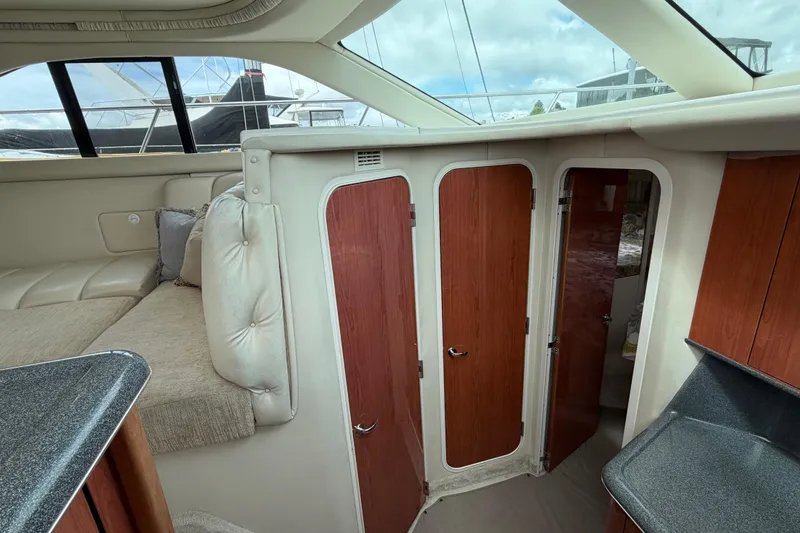 Slide: The Image of Interior of a 1997 Sea Ray 370 Aft Cabin yacht with wood paneling and plush seating. - 23