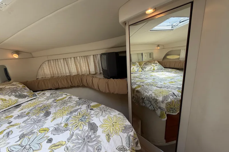 Slide: The Image of Cozy cabin interior of 1997 Sea Ray 370 Aft Cabin with floral bedding and mirror. - 26