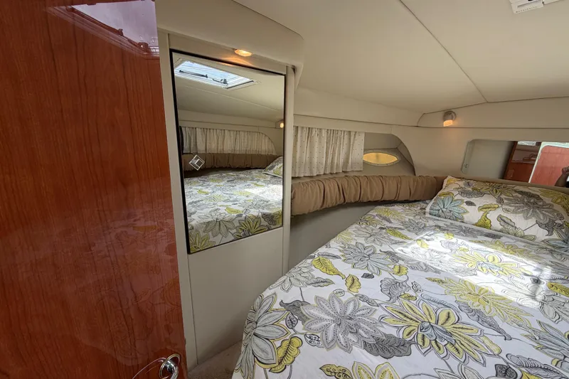 Slide: The Image of 1997 Sea Ray 370 Aft Cabin bedroom with floral bedding and mirrored closet. - 27