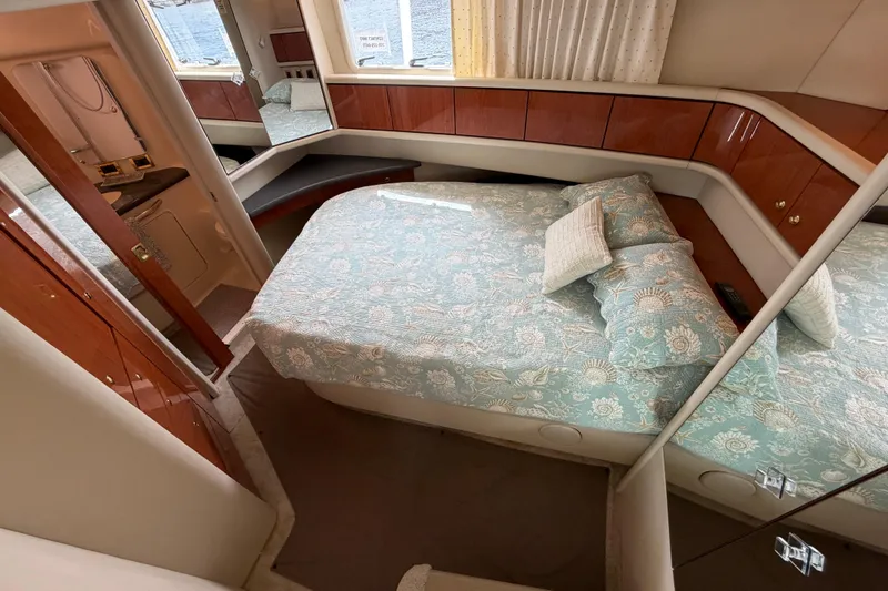Slide: The Image of 1997 Sea Ray 370 Aft Cabin bedroom with floral bedding and wood cabinetry. - 30
