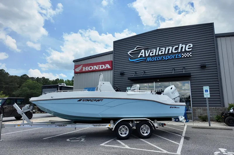 The Image of 2026 Starcraft SVX 211 OB CC boat on trailer at Avalanche Motorsports dealership. - 1