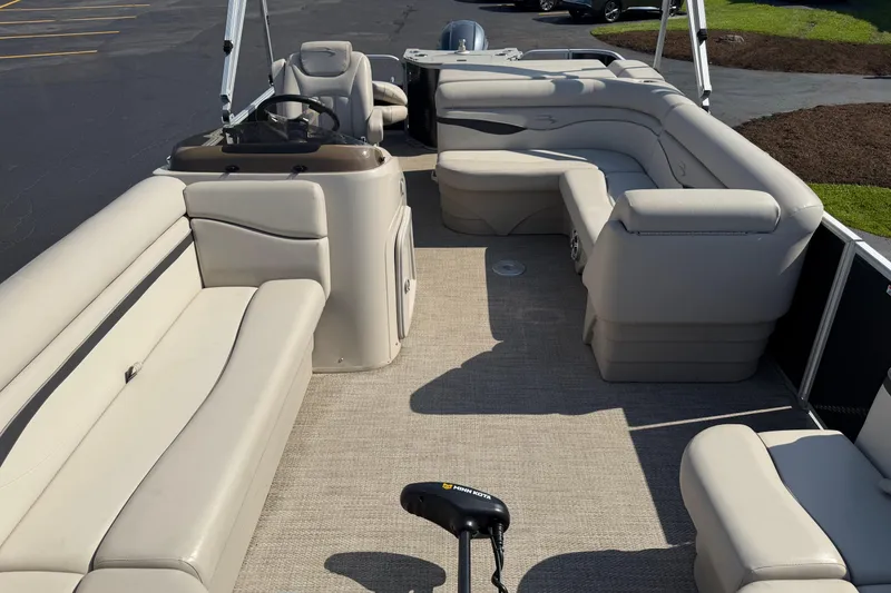 Slide: The Image of 2018 Bennington 21 SF pontoon boat with spacious beige seating and steering console. - 1