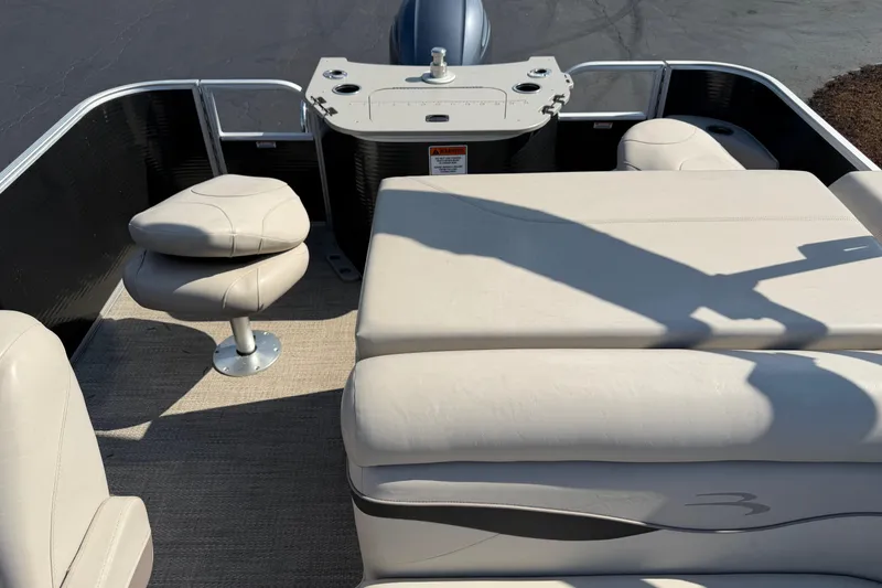 Slide: The Image of 2018 Bennington 21 SF pontoon boat interior with beige seating and helm. - 9