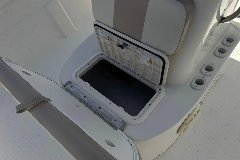 Slide: The Image of 2013 Carolina Skiff Sea Chaser 1950 RG boat storage compartment and rod holders. - 14