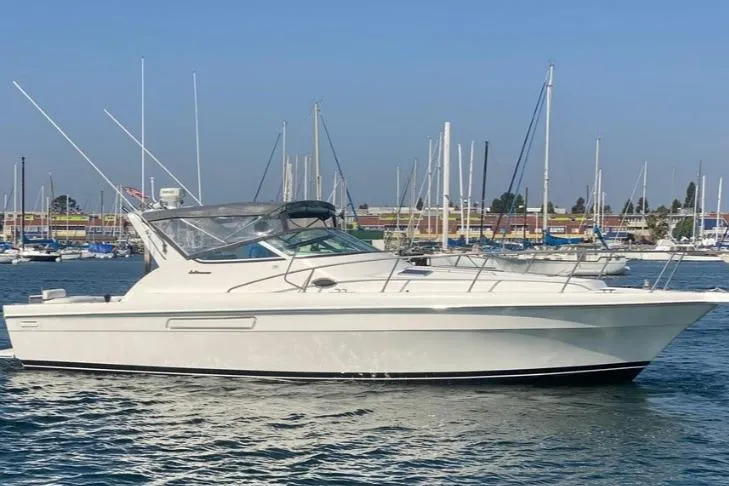 The Image of 2003 Mediterranean 38 Express yacht docked in a marina, surrounded by sailboats. - 5