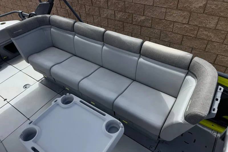 Slide: The Image of 2023 Sea-Doo Switch Cruise 18 interior with gray seating and cupholder table. - 15