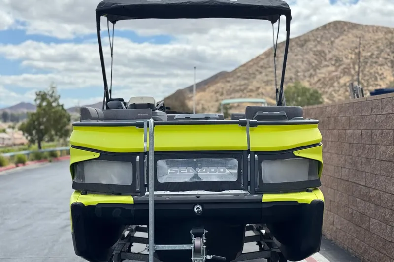 Slide: The Image of 2023 Sea-Doo Switch Cruise 18 in vibrant yellow, parked with scenic mountain backdrop. - 2