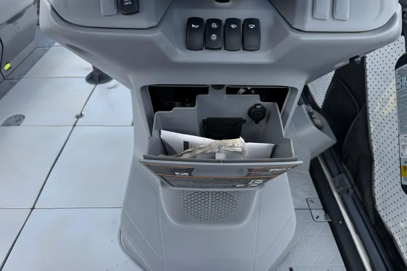 Slide: The Image of 2023 Sea-Doo Switch Cruise 18 dashboard with storage compartment and control switches. - 23