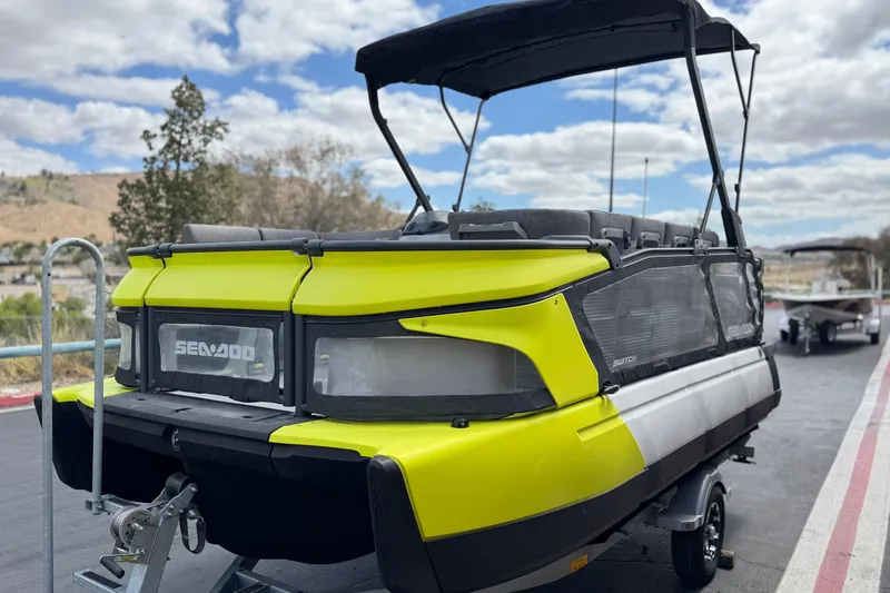 Slide: The Image of 2023 Sea-Doo Switch Cruise 18 pontoon boat on trailer, vibrant yellow and black design. - 3