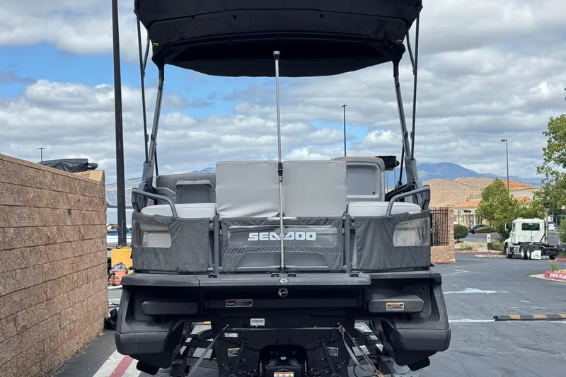 Slide: The Image of 2023 Sea-Doo Switch Cruise 18 pontoon boat parked outdoors, rear view. - 5