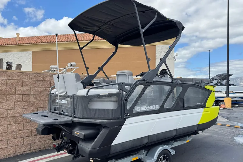 Slide: The Image of 2023 Sea-Doo Switch Cruise 18 pontoon boat with canopy, parked outdoors. - 6