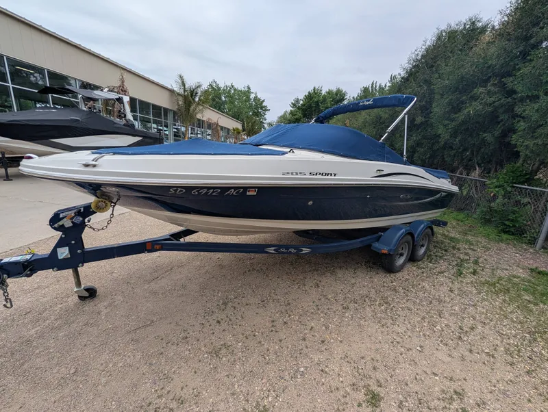 Slide: The Image of 2010 Sea Ray 205 Sport boat on trailer, blue and white. - 2