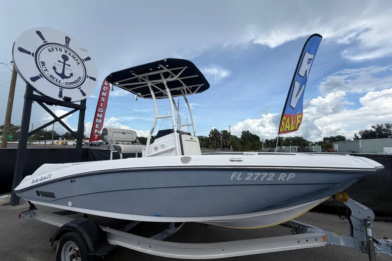 The Image of 2018 Yamaha Boats 190 FSH on trailer at dealership with sale signs. - 0