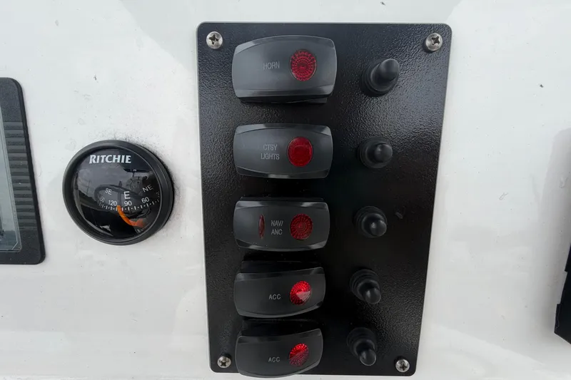 Slide: The Image of Control panel of a 2018 Yamaha Boats 190 FSH with switches and compass. - 26