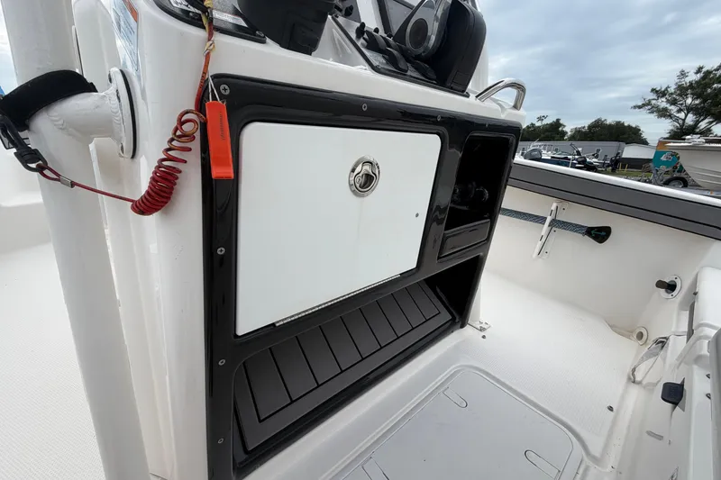Slide: The Image of 2018 Yamaha Boats 190 FSH interior console with storage compartment and safety lanyard. - 29