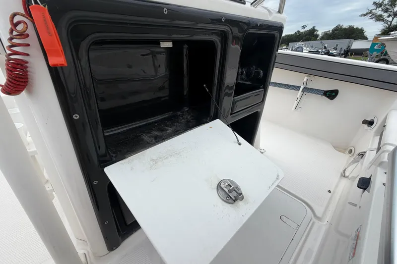 Slide: The Image of 2018 Yamaha Boats 190 FSH storage compartment open, showcasing interior space and latch mechanism. - 30