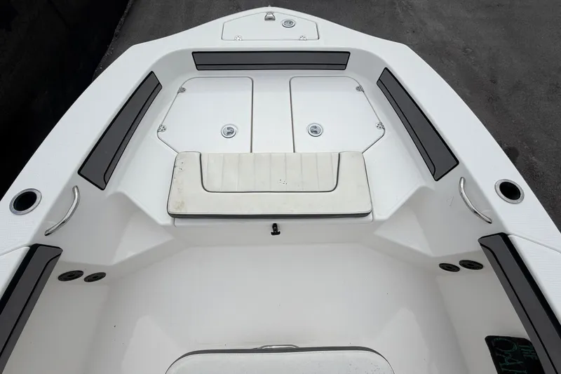 Slide: The Image of 2018 Yamaha Boats 190 FSH interior, featuring sleek white seating and storage compartments. - 32