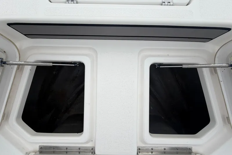 Slide: The Image of 2018 Yamaha Boats 190 FSH storage compartment with open hatches and hinges. - 37