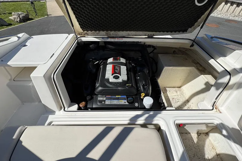 Slide: The Image of 2018 Bayliner 195 Deck Boat engine compartment with open hatch, showcasing the engine. - 2