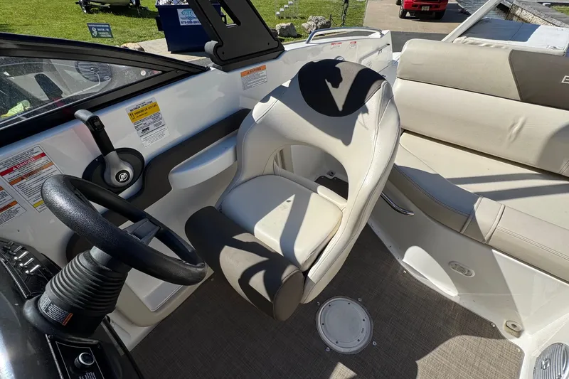 Slide: The Image of 2018 Bayliner 195 Deck Boat interior with steering wheel and seating area. - 5