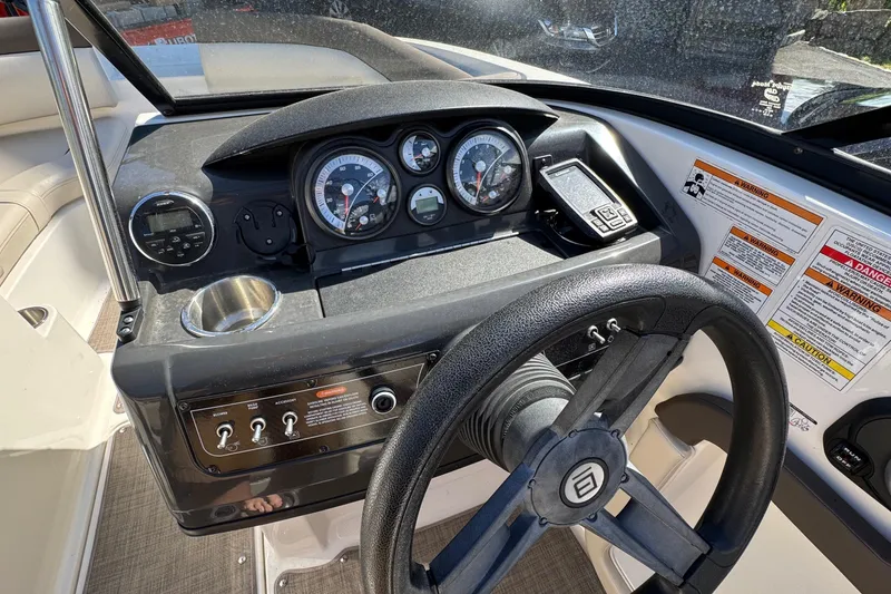 Slide: The Image of 2018 Bayliner 195 Deck Boat dashboard with steering wheel and instrument panel. - 6