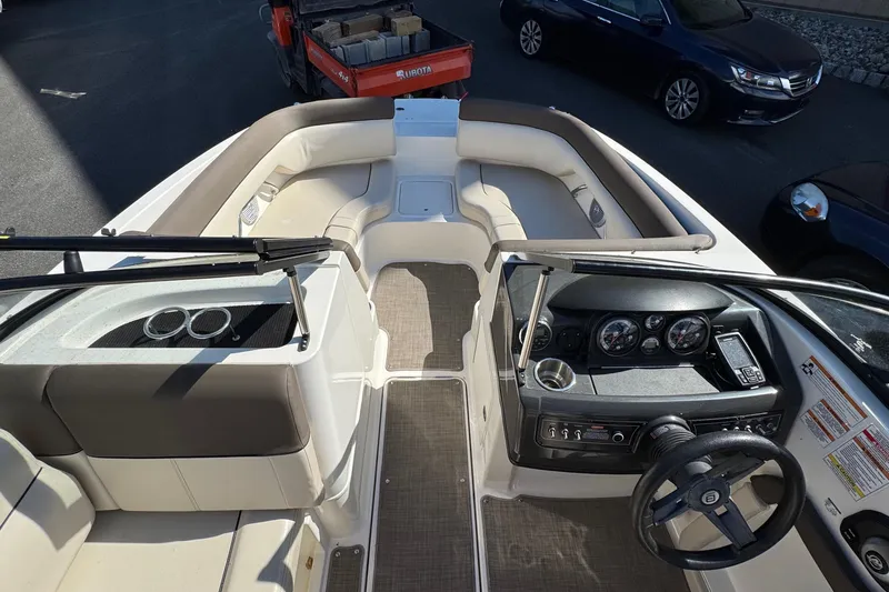 Slide: The Image of 2018 Bayliner 195 Deck Boat interior with steering wheel, seating, and dashboard controls. - 7