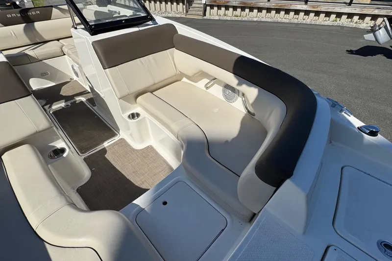 Slide: The Image of 2018 Bayliner 195 Deck Boat interior with beige seating and cup holders. - 8