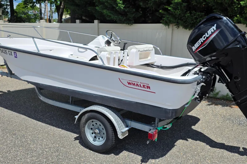 The Image of 2004 Boston Whaler 150 Sport boat on trailer with Mercury outboard motor. - 0