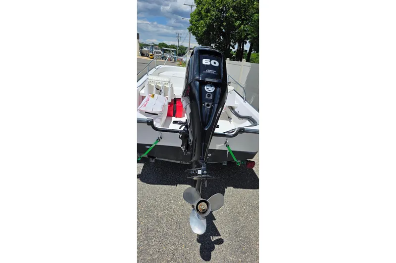 Slide: The Image of 2004 Boston Whaler 150 Sport boat with a 60 HP outboard motor, parked on a trailer. - 1