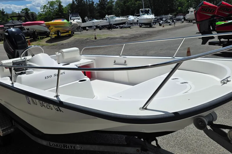 Slide: The Image of 2004 Boston Whaler 150 Sport boat on trailer in marina setting. - 3