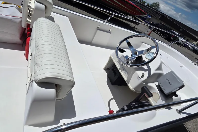 Slide: The Image of 2004 Boston Whaler 150 Sport boat interior with steering wheel and seating. - 4