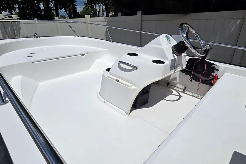 Slide: The Image of 2004 Boston Whaler 150 Sport boat interior with steering console and seating area. - 9