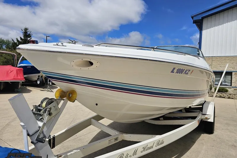 Slide: The Image of 1997 Formula 252 SS boat on trailer, parked outdoors under a blue sky. - 15