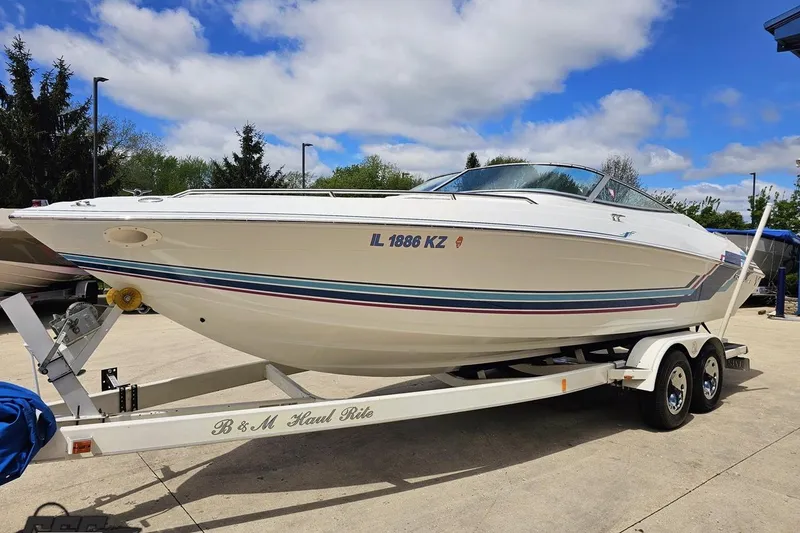 Slide: The Image of 1997 Formula 252 SS boat on trailer, parked outdoors under a blue sky. - 16