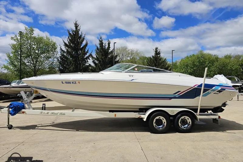 Slide: The Image of 1997 Formula 252 SS boat on trailer, parked outdoors under a partly cloudy sky. - 18