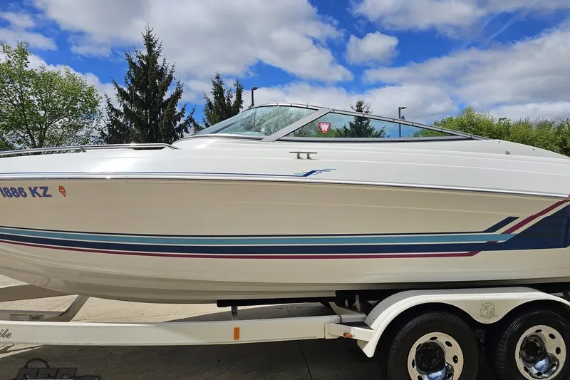 Slide: The Image of 1997 Formula 252 SS boat on trailer, white with blue and red accents, under a cloudy sky. - 19