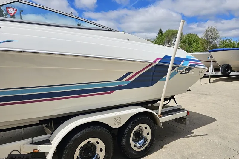 Slide: The Image of 1997 Formula 252 SS boat on trailer, featuring colorful stripes and sleek design. - 20