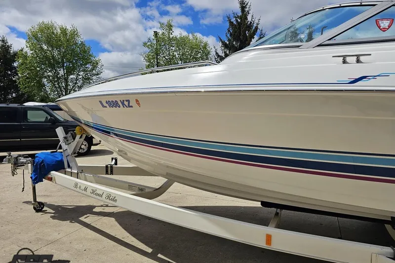 Slide: The Image of 1997 Formula 252 SS boat on trailer, parked outdoors under a partly cloudy sky. - 21