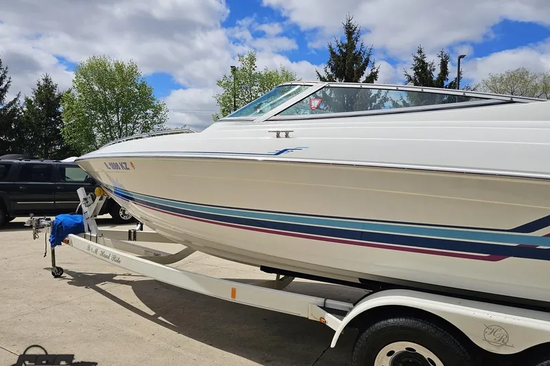 Slide: The Image of 1997 Formula 252 SS boat on trailer, parked outdoors under a partly cloudy sky. - 22