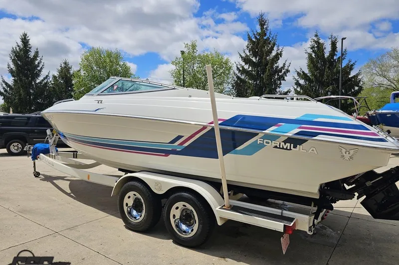 Slide: The Image of 1997 Formula 252 SS boat on trailer, featuring colorful graphics, parked outdoors. - 24