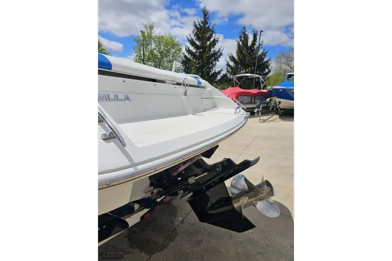 Slide: The Image of 1997 Formula 252 SS boat stern with propeller, parked outdoors under a blue sky. - 26